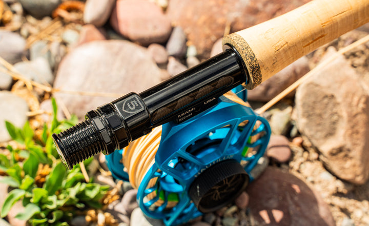 Douglas DXF Gen 2 reel seat and cork grip with a reel fitted, on river rock
