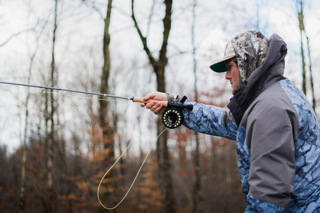 Angler casting a Douglas ERA fly rod on a wooded river in late autumn