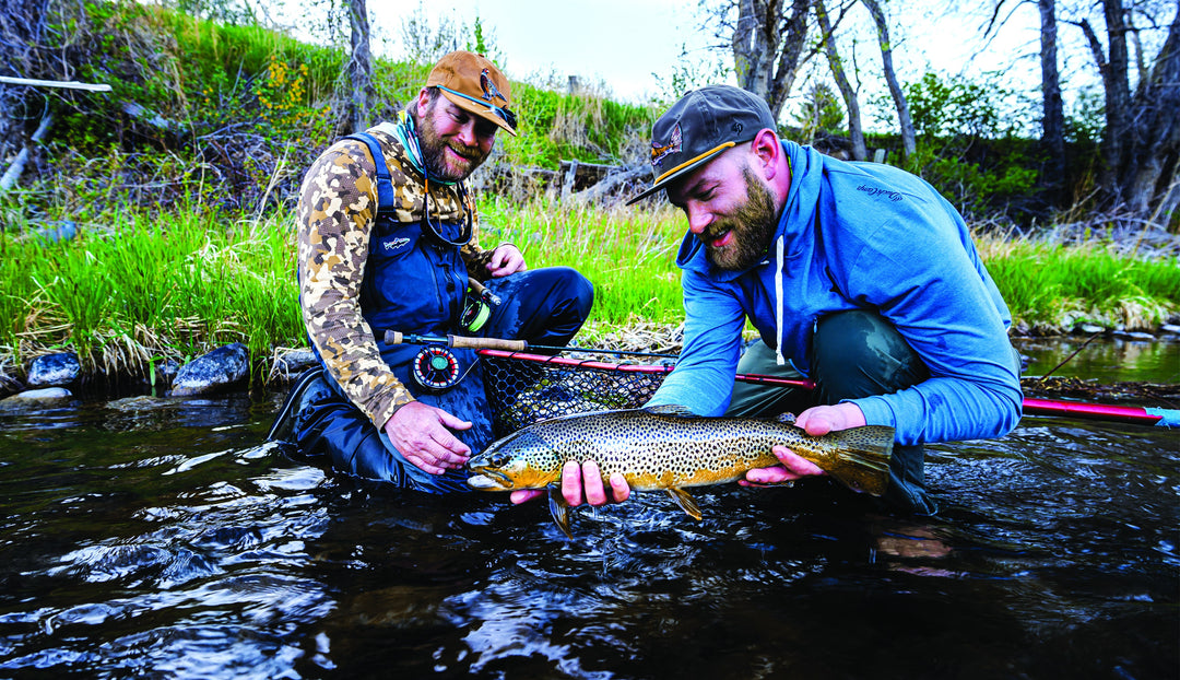 Two anglers releasing a brown trout caught on a Douglas DXF Gen 2
