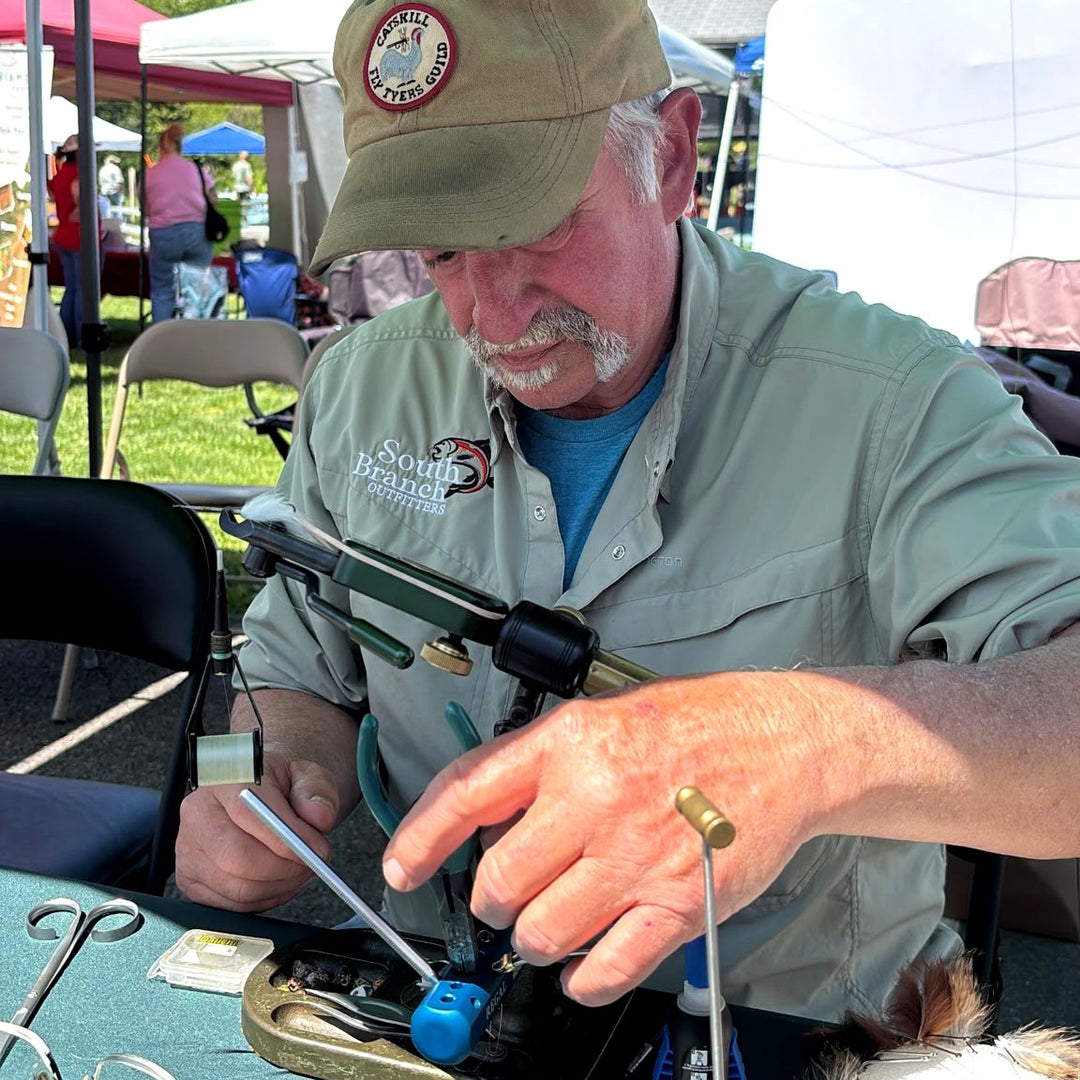 A tyer's hands at the vise during a fly tying demo at Trout Fest